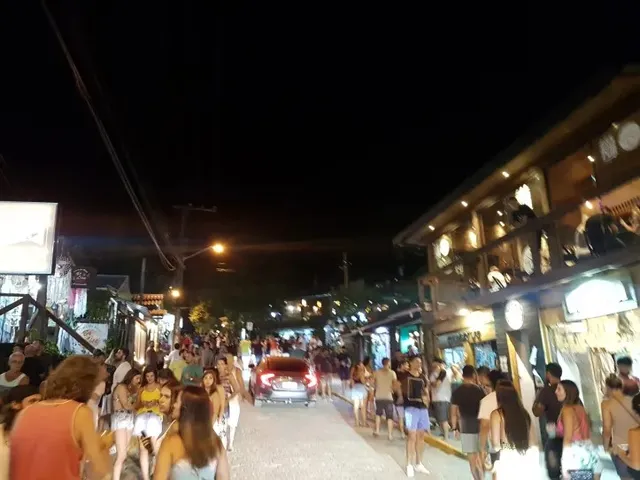 Ruas do centrinho da Praia do Rosa com lojas e movimento