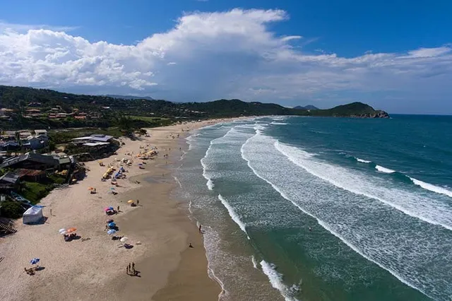 Vista aérea da Praia do Rosa Sul, com o mar e casas na orla