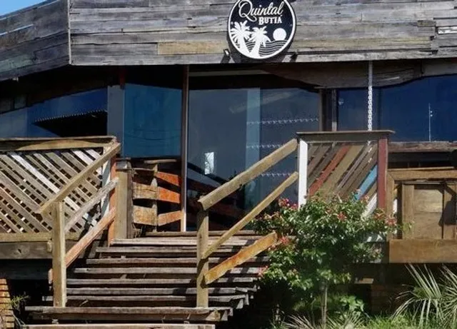 Fachada do Quintal Butiá, com a placa da casa, na Praia do Rosa