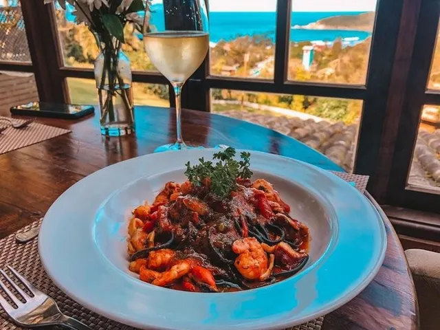 Prato de massa com frutos do mar em um restaurante da Praia do Rosa, com vista para o mar